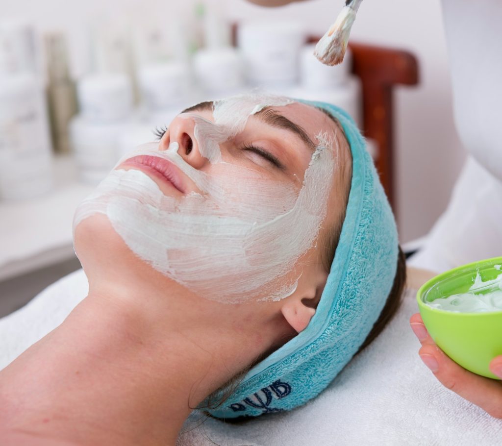 Woman relaxing during spa head and face treatment